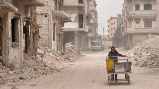 Ein Maisverkäufer im zerstörten Stadtviertel El Khaldiyye in Homs, unterwegs zwischen den Trümmern.
