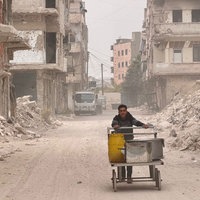 Ein Maisverkäufer im zerstörten Stadtviertel El Khaldiyye in Homs, unterwegs zwischen den Trümmern.