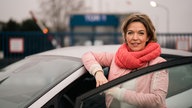 Anna Plancken vor einem Auto in einer Autowaschanlage.