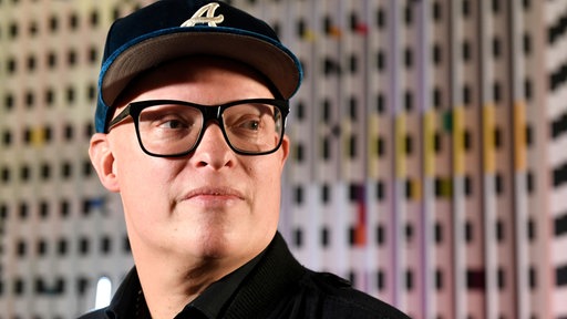 Der Jazz-Gitarrist Torsten Goods trägt eine blaue Basballkappe