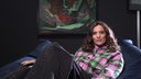 Mona Ameziane sitzt vor einem Kunstwerk
