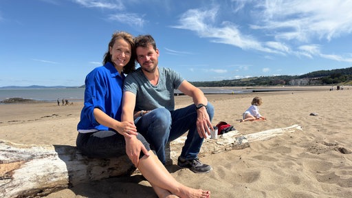Astrid (l) und Torsten (r) mit Blick auf einem Strand.