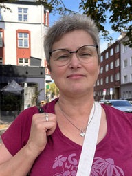 Eine Frau steht auf einem Platz in der Stadt