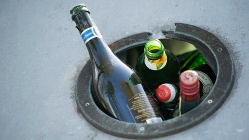 Ein überfüllter Altglascontainer, die Flaschen passen nicht mehr alle hinein