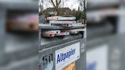 Leere Pizzakartons in einem Altpapiercontainer