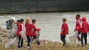 Kinderin roten Jacken sammeln Müll