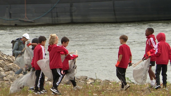 Kinderin roten Jacken sammeln Müll