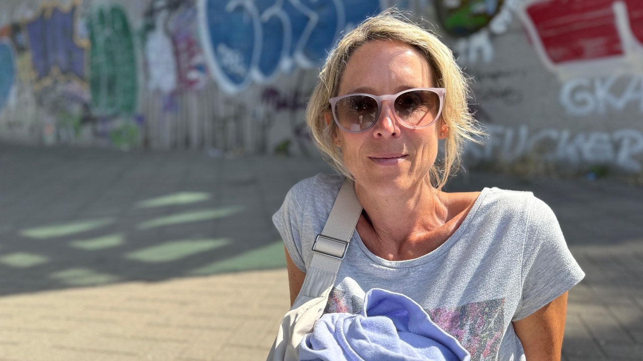 Frau mit Sonnenbrille schaut in die Kamera