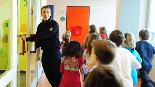 ein Sozialarbeiter mit Kindern in einer Schule