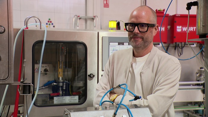 Ein Mann steht in einer Produktionshalle