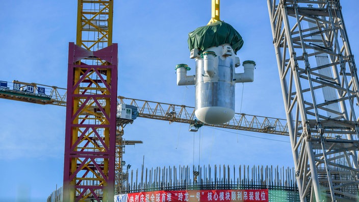 Der kleine Reaktor "Linglong One" aus China hängt an einem Kran