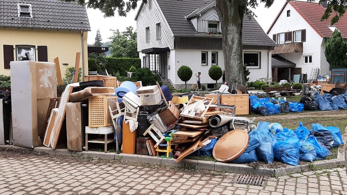 Sperrmüll aus nassen Garagen, Kellern und Häusern steht in Erkrath bei den Aufräumarbeiten auf der Straße