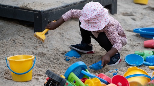 Mädchen spielt im Sandkasten