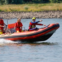 Einsatzkräfte der Berufsfeuerwehr Köln, der DLRG und Rettungstaucher auf einem Schlauchboot im Rhein