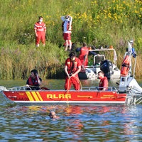 Einsatzfahrzeuge der Polizei und Feuerwehr auf einem See