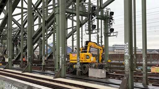 Gelbes Baufahrzeug auf den Gleisen des Kölner Hauptbahnhofs