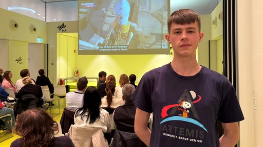 Benjamin Deiters im T-Shirt der ersten Artemis Mission
