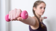 Eine Frau trainiert mit einer 0,5 Kilo Hantel 