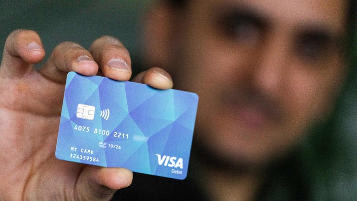 Offenburg: Ein Geflüchteter hält eine Debitcard in der Hand