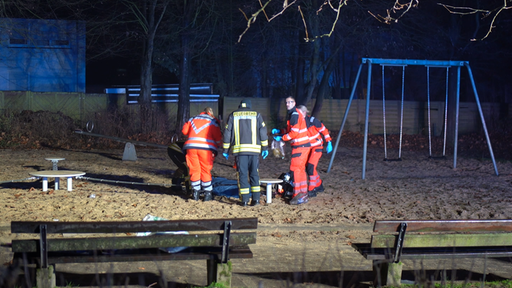 Rettungskräfte stehen auf einem Spielplatz in Bielefeld nach einem tödlichem Unfall durch Pyrotechnik.