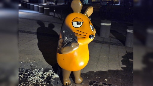 In der Nacht auf den 26. Juli wurde ein Brandanschlag auf die Maus vor den WDR Acarden in Köln ausgegübt, die linke Flanke der Figur ist verkohlt 