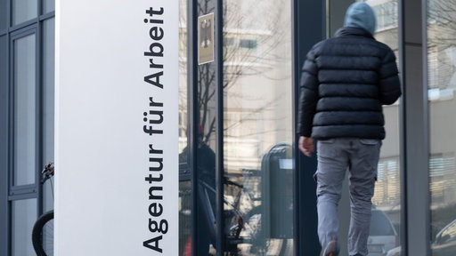 Eine Person geht in die Agentur für Arbeit