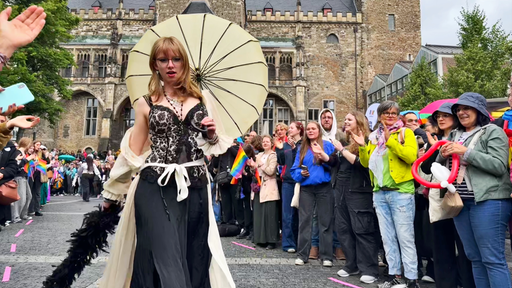 Frau in schickem Kleid mit Regenschirm bei CSD-Modenschau in Aachen