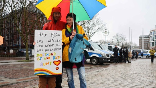 Zwei Demonstranten halten ein Schild mit der Aufschrift "Dortmund ist und bleibt bunt!"
