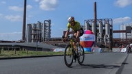 Ein Rennradfahrer fährt auf dem Gelände der Zeche Zollverein in Essen