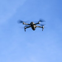 Eine Drohne fliegt vor einem startenden Flugzeug in der Nähe des Flughafens Leipzig/Halle