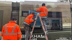 Arbeiter kleben ein zerstörtes Fenster der Tram ab