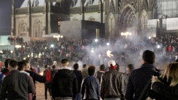 Zahlreiche Menschen stehen auf dem Vorplatz des Kölner Hauptbahnhofs vor dem Dom. 
