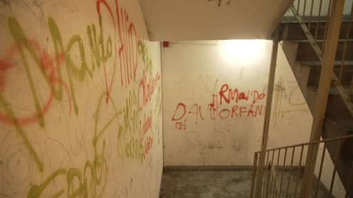 Ein Treppenhaus mit bemalten und dreckigen Wänden 