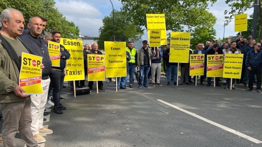 Taxifahrer demonstrieren in Essen mit Schildern gegen Uber
