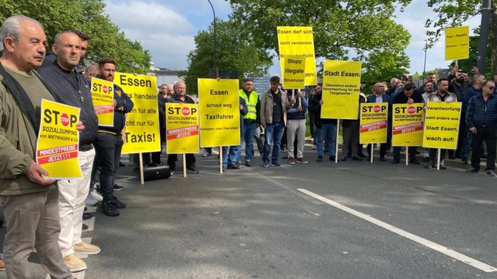 Taxifahrer demonstrieren in Essen mit Schildern gegen Uber