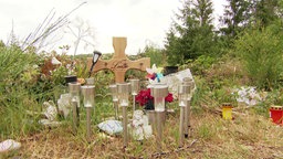 Ein Kreuz und Kerzen in Gedenken an Luise