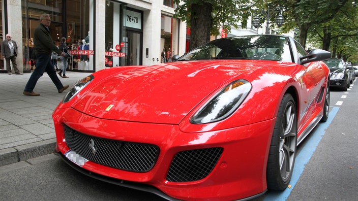 Ein Ferrari-Sportwagen parkt auf der Königsallee in Düsseldorf.
