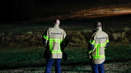Einsatzkräfte der Feuerwehr beobachten den Brand im Hohen Venn. 