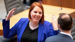 Franziska Müller-Rech hebt ihre Arme in einem Gespräch