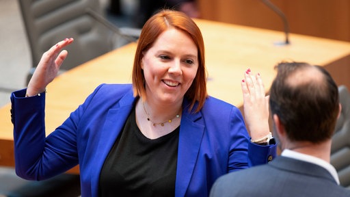 Franziska Müller-Rech hebt ihre Arme in einem Gespräch
