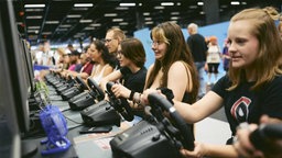 Besucher der Gamescom testen Videospiel-Lenkräder 