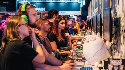 Besucher auf der Gamescom 2025 in Köln testen Videospiele 