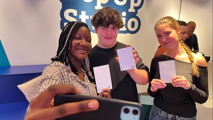 Drei junge Besucher des WDR Pop-Up-Studios machen ein Selfie.