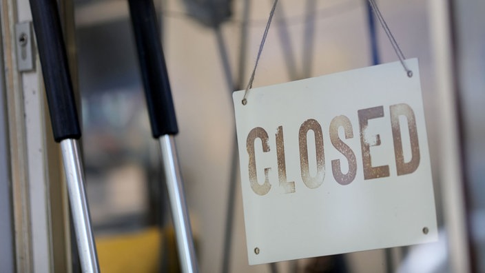 Ein Schild mit der Aufschrift "closed" (geschlossen) hängt am Eingang eines Geschäftes in Köln.