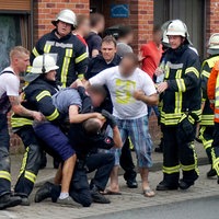 Drei Männer behindern nach einem Unfall die Arbeit der Rettungskräfte.