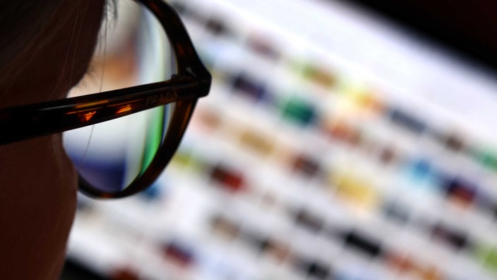 Eine Frau mit Brille schaut sich Bilder auf Google an 