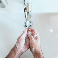 eingeseifte Hände über einem Waschbecken