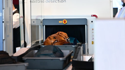 Handgepäck fährt am Flughafen in einen CT-Scanner 