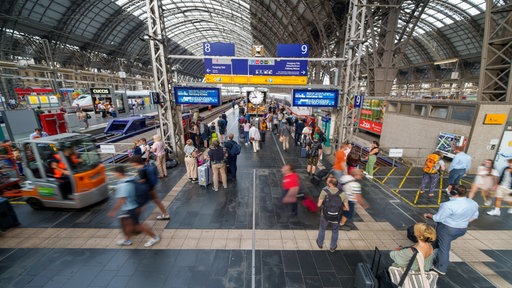 Reisende gehen durch den Hauptbahnhof in Frankfurt am Main