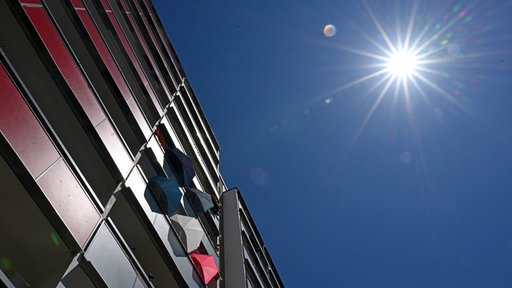Sonnenschirme auf dem Balkon eines Plattenbaus als Schutz vor Sonne